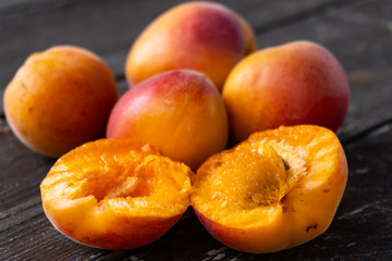 Close up of fresh apricots on an old black wooden table