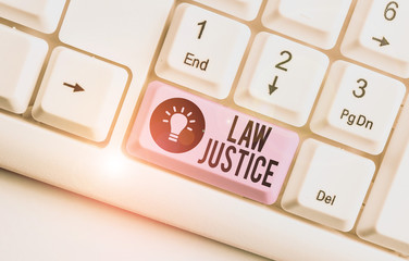 Writing note showing Law Justice. Business concept for a scheme or system of law in which every demonstrating receives White pc keyboard with note paper above the white background