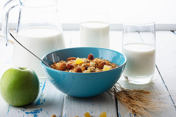Health food. Muesli with milk and the baked apple on old wooden background. High key. Close up. Selective focus.