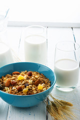 Health food. Muesli with milk and the baked apple on old wooden background. High key. Close up. Selective focus.