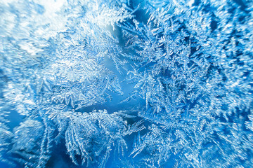 Beautiful frozen patterns on glass, macro photo. The concept of winter, the beauty of nature, frost, cold. Abstract background image.