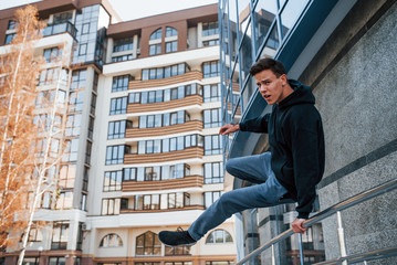 Young man doing parkour in the city at daytime. Conception of extreme sports