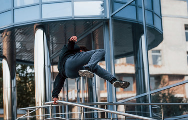 Young man doing parkour in the city at daytime. Conception of extreme sports