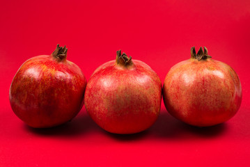 Sweet pomegranate on red background.