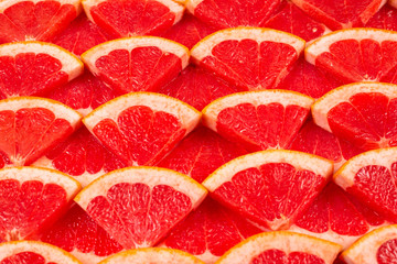 Grapefruit red juicy slices background. top view.