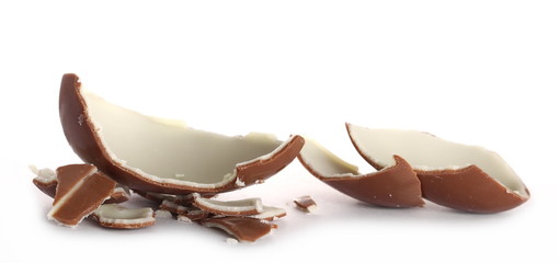 Broken chocolate egg with pieces isolated on white background