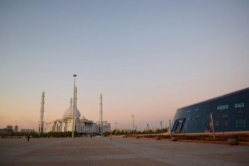mosque meets modern architecture at sunset