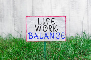 Text sign showing Life Work Balance. Business photo text stability demonstrating needs between his job and demonstratingal time Crumpled paper attached to a stick and placed in the green grassy land