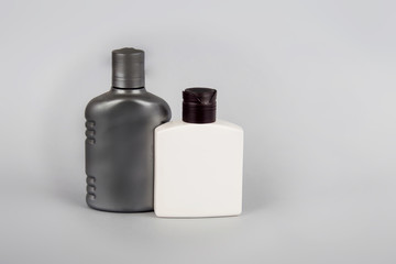 Gray and white bottles on a gray background. Cosmetic bottles. body care.