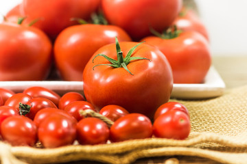 chery tomatoes on wooden board with linen sack, selective focus