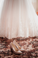 Obraz na płótnie Canvas Pair of high heel shoes and white wedding dress
