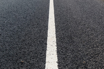 White solid line. Road marking on an asphalt road.