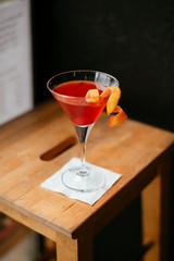 Red Cosmopolitan cocktail served on bar counter.