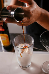 Close up of bartender making martini. Cocktail based on milk and coffee.