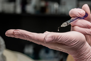 contour plastic. A cosmetologist injects a botulinum toxin to tighten and smooth out wrinkles on the skin of a female face.