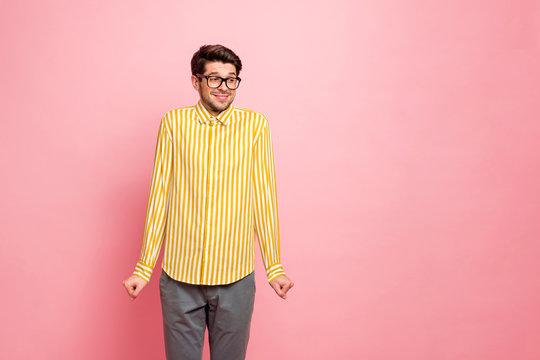 Photo of amazing guy looking side empty space avoiding eyes shy person listen compliments wear specs stylish striped shirt trousers isolated pink color background