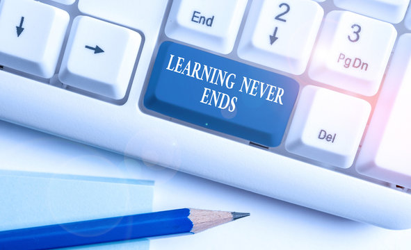 Conceptual hand writing showing Learning Never Ends. Concept meaning Life Long Educational and Wellness Opportunities White pc keyboard with note paper above the white background
