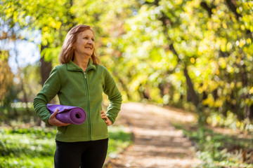 Happy senior woman is ready for exercising in park.