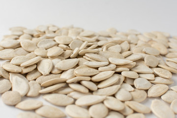 Roasted pumpkin seeds with salt on white background.