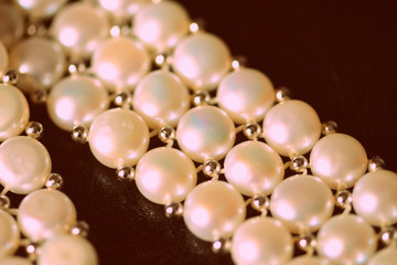 White pearl necklace on a dark background close-up, retro style