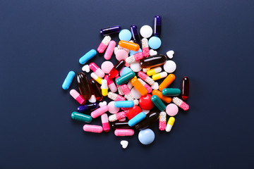 Flat lay composition with bunch of different colorful pills in scattered all over the table. Pile...