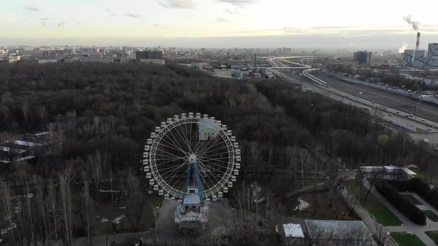 Park in the industrial zone. The Ferris wheel in the autumn Park. Moving in a circle around the damn wheel. travel around the amusement Park. View of the lake in the city, amusement park