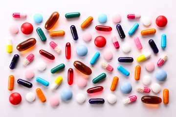 Flat lay composition with bunch of different colorful pills in scattered all over the table. Pile...