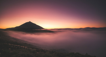 beautiful violet sunset at the mountain with clouds and high vulcan in background - coloured outdoor national nature park - travel and enjoy the scenic place concept