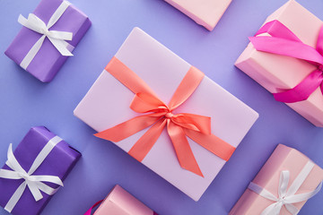 flat lay with colorful presents with bows on purple background