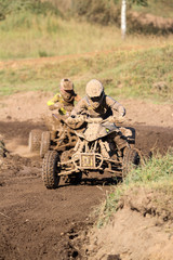 Fototapeta premium Motocross quad race with races who are covered with mud in an old motocross track. 