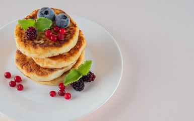 Beautiful pancakes decorated with berries on a light background. Copy space.