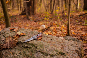 hiking knife on a stone in the forest