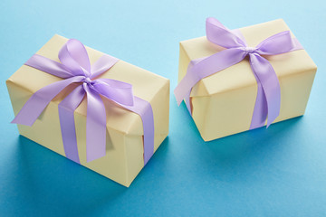 yellow colorful gift boxes with violet ribbons and bows on blue background