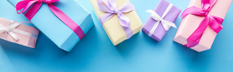 top view of colorful gift boxes on blue background, panoramic shot