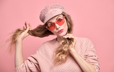 Easy-going Woman happy open-eyed in Stylish fashion pink colored outfit. Beautiful young funny blonde Girl in Trendy jumper, make up. Joyful surprised lady in pink cap, fashionable fun concept