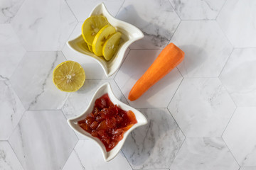Homemade carrot jam with lemon, sugar and vanilla. In a saucer on a light background. Healthy dessert