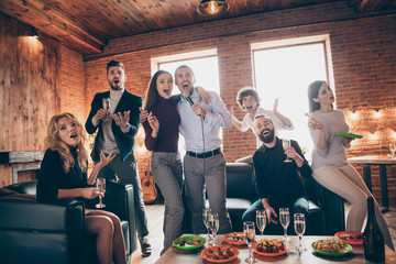 Photo of best amazing friends celebrating birthday party singing karaoke songs hold microphone drink golden wine eat snack food wear formalwear sitting sofa restaurant indoors