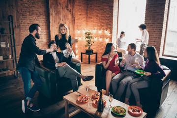 Photo of eight members group festive birthday party people friendship chatting clinking glasses drink golden wine eating snacks wear formalwear sitting sofa indoors