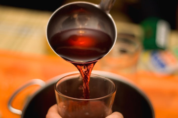 Pouring homemade mulled wine. Selective focus.