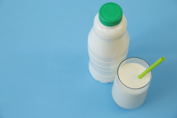 bottle of bio kefir and glass of kefir on the blue background with copy space for text. Dairy products.