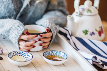 a warm tea to heat a cold winter. The girl is holding herbal tea. a cup of linden tea
