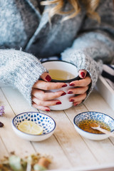 a warm tea to heat a cold winter. The girl is holding herbal tea. a cup of linden tea
