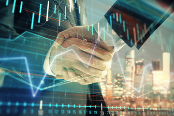 Double exposure of financial chart on cityscape background with two businessmen handshake. Concept of financial analysis and investment opportunities