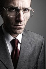 Portrait of a serious businessman looking at the camera behind a pair of spectacles