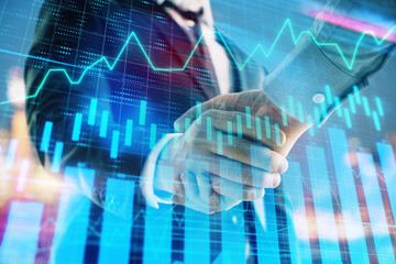 Fototapeta na wymiar Double exposure of financial chart on cityscape background with two businessmen handshake. Concept of financial analysis and investment opportunities