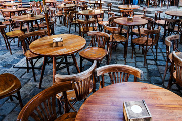 Empty round wooden tables at a street cafeteria