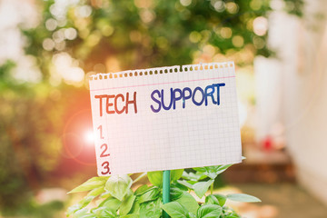 Text sign showing Tech Support. Business photo showcasing advising and troubleshooting service provided by a analysisufacturer Plain empty paper attached to a stick and placed in the green leafy