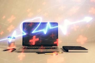 Heart hologram with desktop office background. Double exposure. Concept of medical education