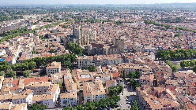 Scenic panoramic aerial view of residential areas of Narbonne with medieval Roman Catholic Cathedral on sunny summer day, France