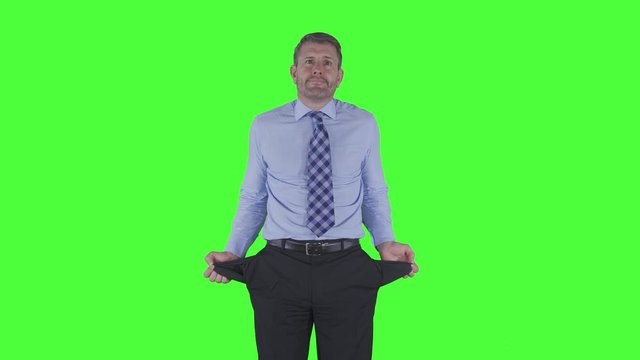 Caucasian businessman showing empty pockets in the studio. Shot in 4k resolution with green screen background
